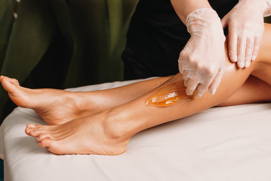 Close-up photo of sugaring procedure done on a leg