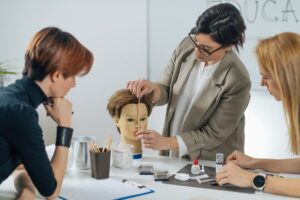 Cosmetology instructor measures mannequin face in a classroom