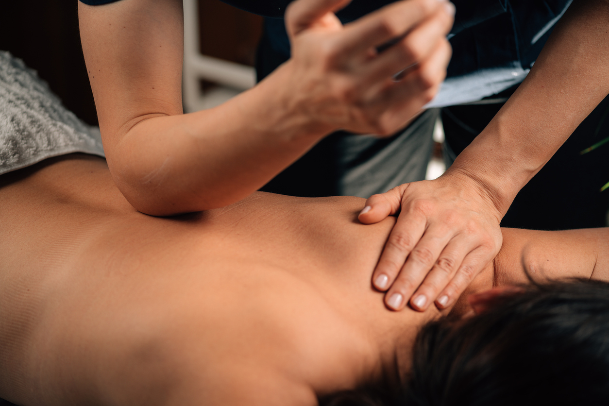 Patient face down on massage table receiving deep tissue massage