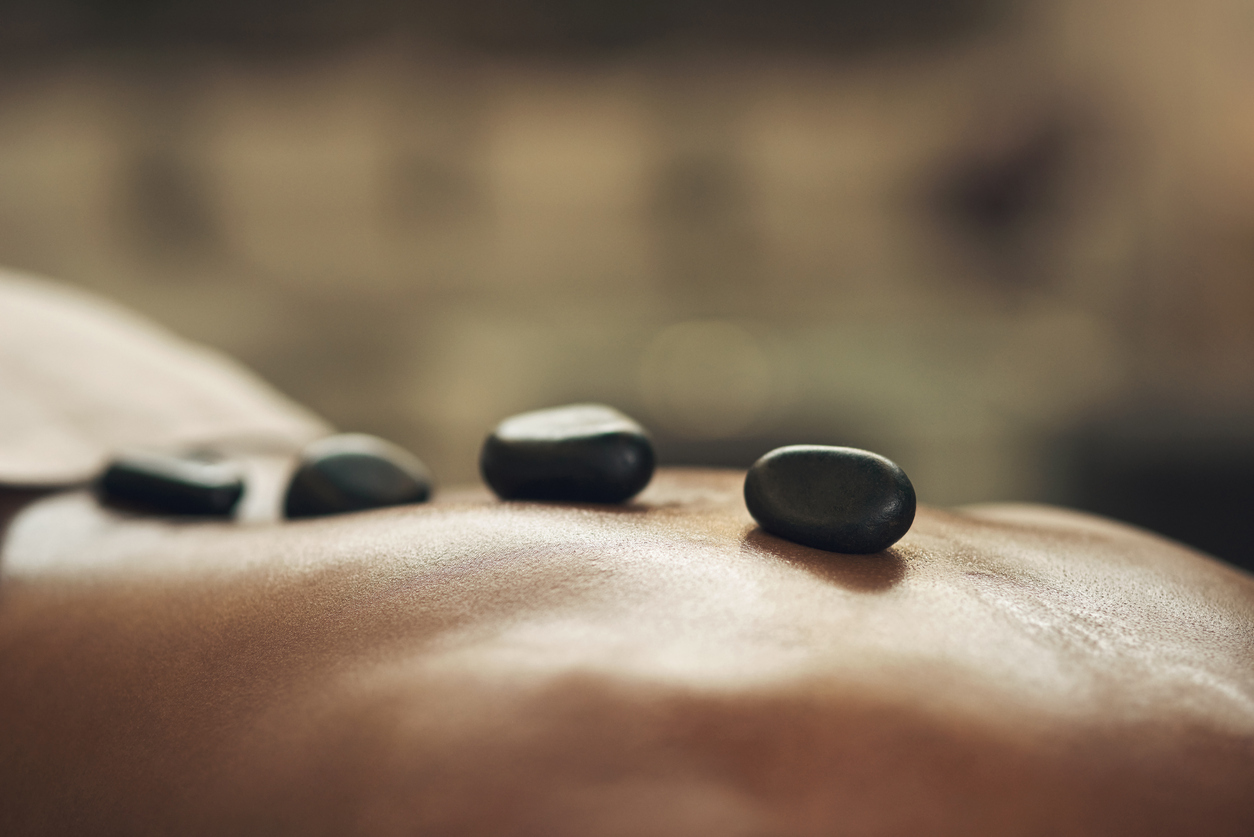 Client with hot stones placed on back during hot stone massage