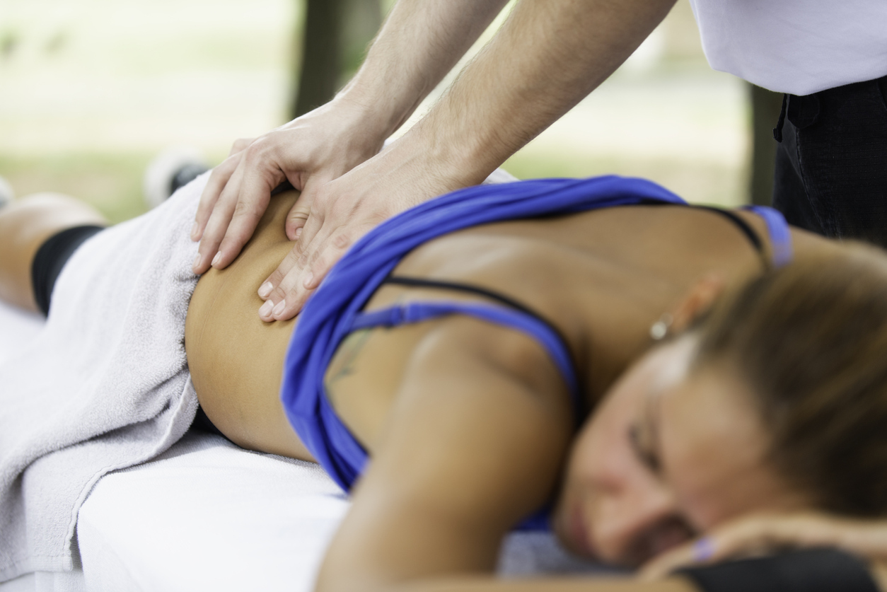 Sports massage therapist working on client’s back
